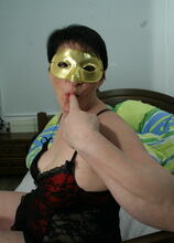 Masked mature slut playing with her body